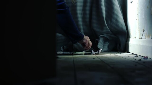 Door opens to reveal addict cutting Illegal drugs in abandoned house