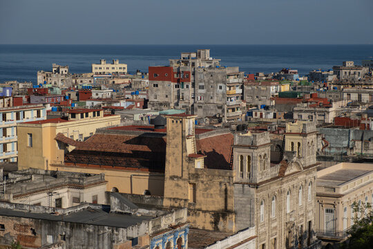 Aerial cityscape view - old crumbling building, weathered worn facades and shingled roofs with water tanks, overpopulated city, Havana, Cuba. 
