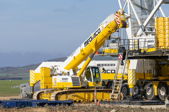 Lemoncourt, France - November 11th 2025 : View on a white and yellow telescopic crawler crane Liebherr LTR 1100 on a construction site of a wind farm with a lattice boom crane Liebherr LG 1750 behind.