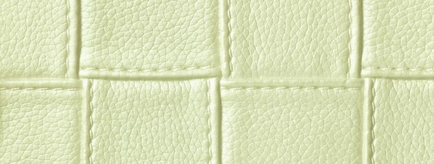 Fototapeta premium Texture light green leather background with quilted stitched pattern, macro. Abstract pastel olive upholstery surface