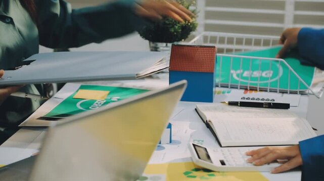 Business leaders discuss implement environmental sustainability strategies net zero carbon goals corporate responsibility using ESG reports data at meeting