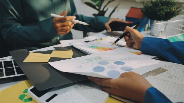 Business leaders discuss implement environmental sustainability strategies net zero carbon goals corporate responsibility using ESG reports data at meeting