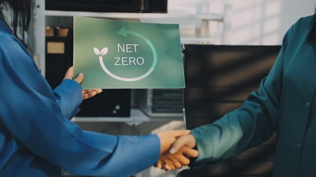 Business leaders discuss implement environmental sustainability strategies net zero carbon goals corporate responsibility using ESG reports data at meeting