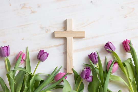 Wood cross with pink and purple tulips on white