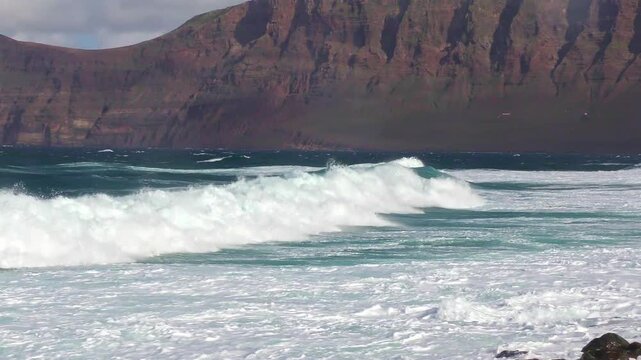 Impressive coastal landscape with large foaming waves, blue sky, surf, shore, sea, ocean, Canary Islands, Lanzarote, rocky, vacation, adventure, horizon
