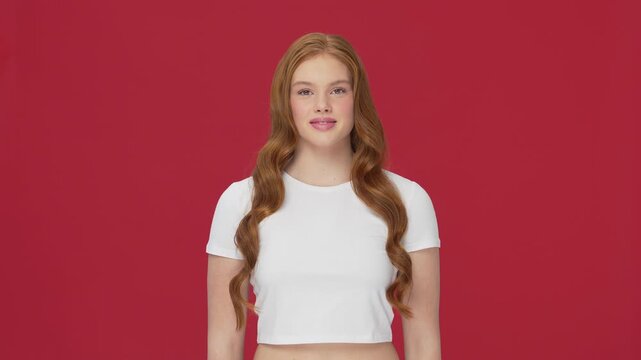 Beautiful teenage redhead girl posing in studio. Female of cute female teenager over bright solid background. Close-up face of young Caucasian woman.