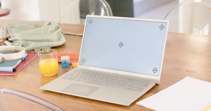 Camera is slowly zooming and shifting, showcasing silver laptop with crosshair screen on table