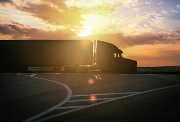 Truck drives down the road at sunrise.
