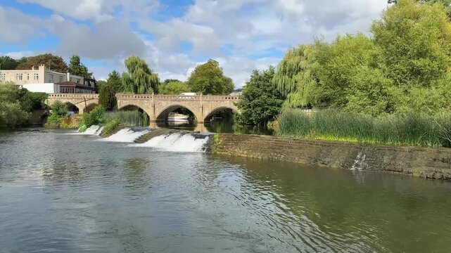 River Avon flowing over weir at Bathampton, Somerset on sunny summer day