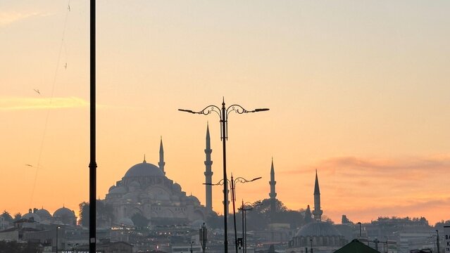 Breathtaking sunset silhouette of the historic Suleymaniye Mosque in Istanbul, Turkey. Urban cityscape with people during Ramadan vibes, showcasing Ottoman architecture and Muslim faith against a warm