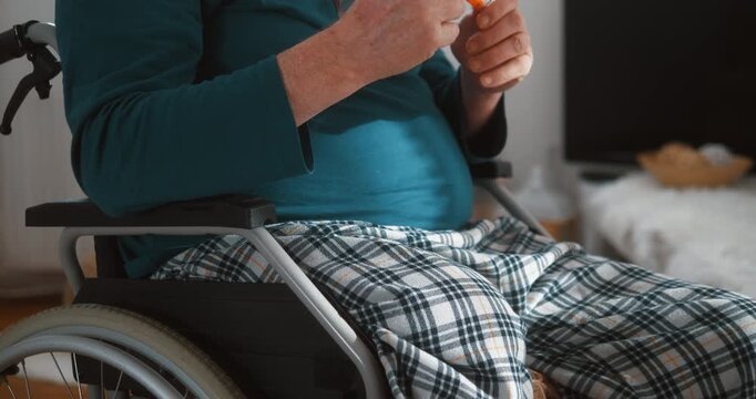 Senior man with disability in wheelchair injecting insulin at home. Concept of diabetes management, self care, chronic illness treatment and healthcare.
