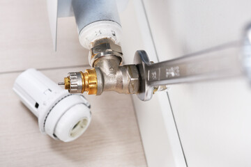 Installation or repair of a thermostatic radiator valve with a key.