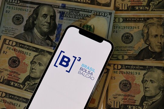 Salvador, Brazil - February 12, 2026: B3 (Brasil Bolsa Balc&atilde;o) logo on a smartphone screen over US dollar bills. Foreign Investment, Brazilian stock market. Ibovespa Brazil. 