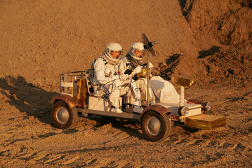 Two astronauts sitting in a planetary rover during a scouting mission on a desert planet. © Tetiana Tuzyk