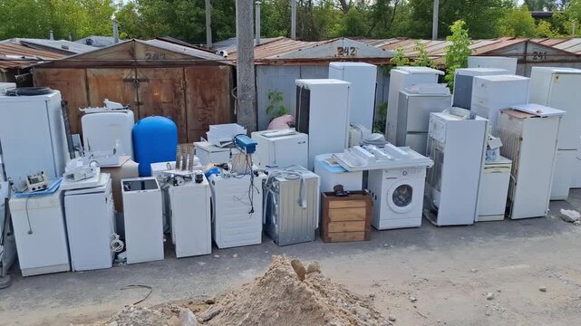 Old washing machines and refrigerators at point of reception of non-working techniques. Old household appliances will be dismantled, sorted by metals and sent for recycling, something will be repaired