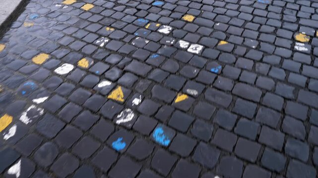 Steadycam shot moving over traditional Roman cobblestone pavement known as sanpietrini in the historic center.