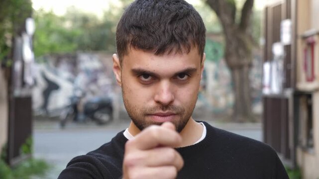 A very serious young man gestures clearly that money is needed to do the job, expressing firm conditions and financial expectation.