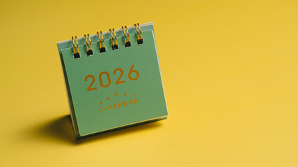 2026 calendar on yellow background, showcasing modern design with spiral binding. This vibrant image captures essence of planning and organization