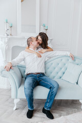 Obraz premium Father and daughter at home on the sofa, a warm family portrait.