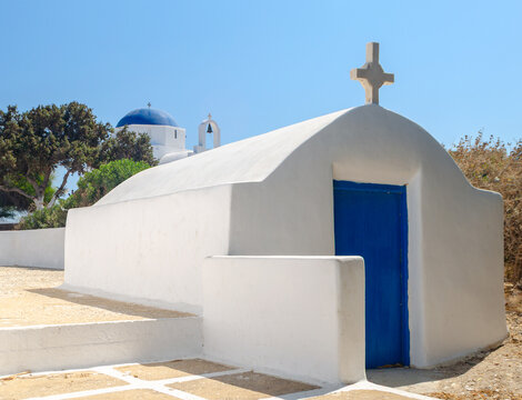 Small blue and white traditional chapel, Antiparos Chora, Greece with the larger Agia Marina church behind