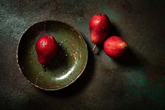Red pear in green bowl 