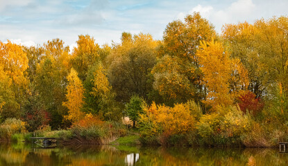 Obraz premium Autumn or indian summer view with reflections in a pond at Wallersdorf, Dingolfing, Landau, Bavaria, Germany
