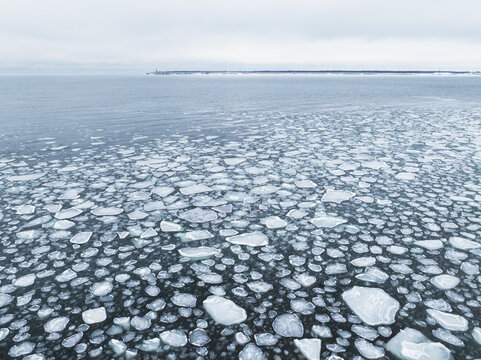 Aerial drone view of frozen sea water with floating ice floes in the strait between Paldiski peninsula and Pakri islands.