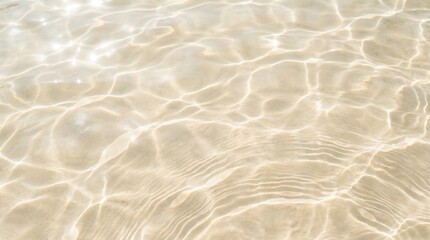 Sunlight shimmering through clear shallow water onto a sandy ocean floor creating light patterns