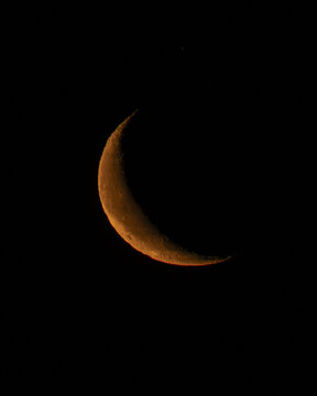 A red crescent moon on a black sky
