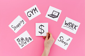 Hand is choosing Dollar card from many paper cards with hand drawing of different life activities. Life balance concept.
