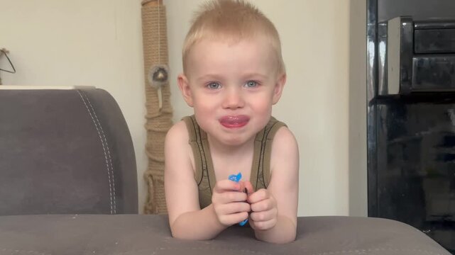 Video. A 2-year-old boy looks at the camera and smiles.