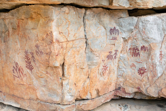 Red ochre schematic anthropomorphic and solar motifs in La Batanera rock art, Fuencaliente Spain