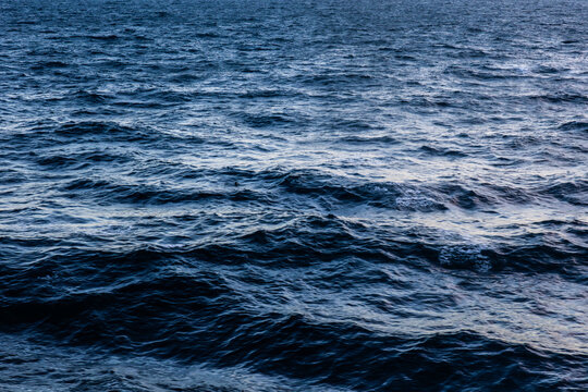 Ocean surface texture top view wavy deep blue reflective abstract, pattern photo.