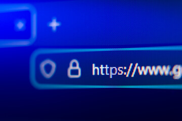 Close-up of a secure web browser address bar with HTTPS protocol, padlock icon, and shield symbol, representing internet security, data privacy, and encrypted connection. © Rokas
