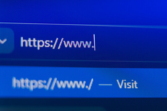 Close up of a web browser search bar on a blue pixelated screen showing a secure https prefix with a flashing cursor, representing web navigation, internet connectivity, and cyber security.