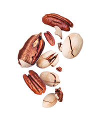 Dried crushed pecan nuts in the air close-up isolated on white background