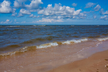 Obraz premium Waves Crashing on Baltic Sea Sandy Beach at Sunny Day in Kolka, Latvia