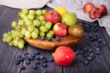 Różne owoce w drewnianej misie © Katarzyna