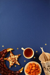 Ramadan food background with top copy space. Vertical composition featuring dates, nuts, dried...