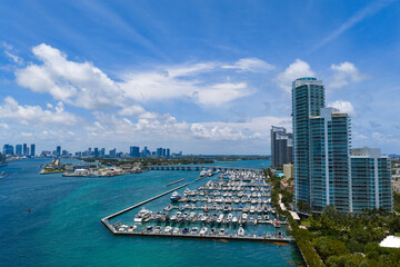 Obraz premium Luxury yacht docked at Miami marina. Aerial view of coastline in Miami. Sailboat cruising along the Miami shore.