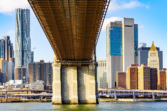 New-York, USA - 27.12.2025: Manhattan Bridge underside over the East River with Lower Manhattan skyline and Verizon building, New York City urban architecture