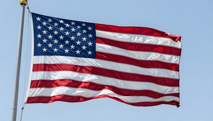 Obraz premium American flag waving in the wind against a clear blue sky backdrop