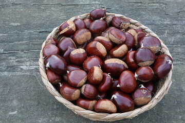 Obraz premium Chestnuts in wicker basket from autumn harvest