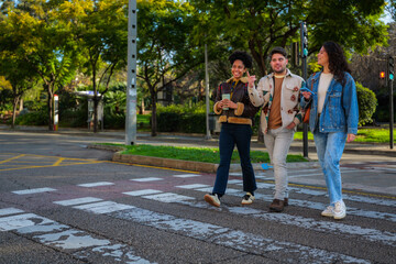 Obraz premium Diverse friends enjoying a conversation while walking across a pedestrian crosswalk in a vibrant urban environment, representing friendship, connectivity, and modern city life