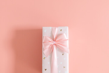 One gift box with a bow on a pink background.