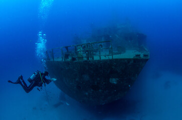 Scuba diver next to stern of Um El Faroud shipwreck, Wied iż-Żurrieq, Malta, Mediterranean Sea