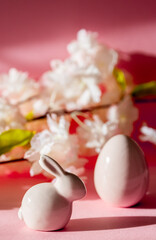 Porcelain Easter eggs and bunny on a pink background.