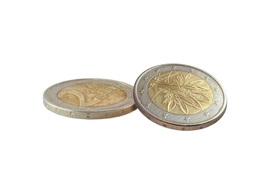 Two French 2 euro coins. One shows the "Tree of Life" Oak and olive branches obverse in a tilted view; the other lies flat showing the reverse face value. Bimetallic gold and silver tones cut out.