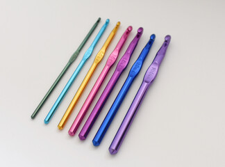 Fototapeta premium Top view of colorful crochet hooks arranged in a row. Creative DIY and craft concept for knitting, crochet projects, and handmade hobbies. 