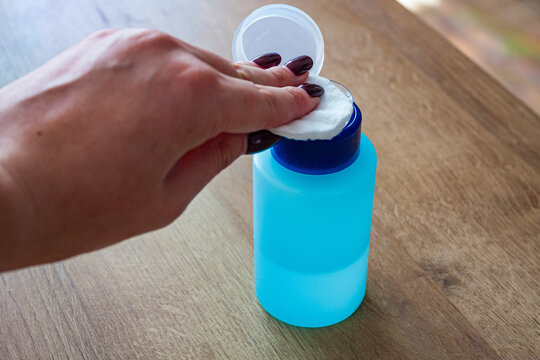 Woman applying nail polish remover acetone on a cotton pad